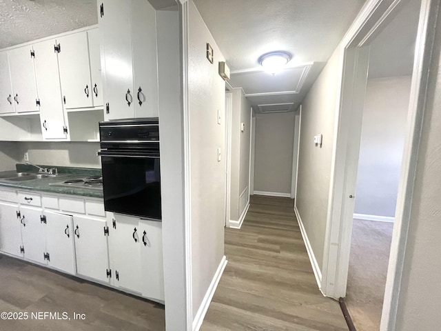 kitchen featuring white cabinetry, sink, black appliances, and light hardwood / wood-style floors