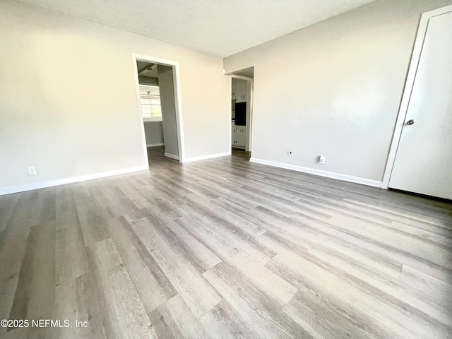 unfurnished bedroom with a closet, a textured ceiling, and light wood-type flooring