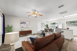 living room featuring ceiling fan and dark wood-type flooring