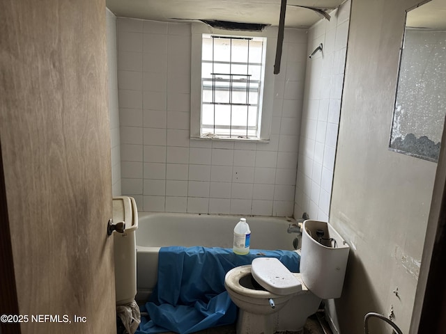 bathroom featuring tiled shower / bath combo and toilet