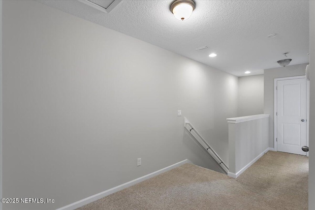 staircase featuring carpet flooring and a textured ceiling