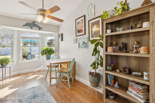 dining room with ceiling fan, light hardwood / wood-style flooring, and lofted ceiling