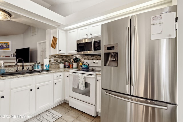 kitchen with white cabinets, sink, light stone countertops, light tile patterned floors, and stainless steel appliances