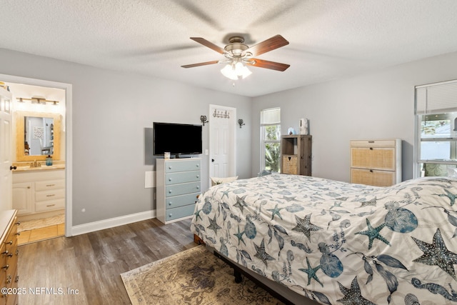 bedroom featuring sink, ceiling fan, a textured ceiling, connected bathroom, and dark hardwood / wood-style flooring