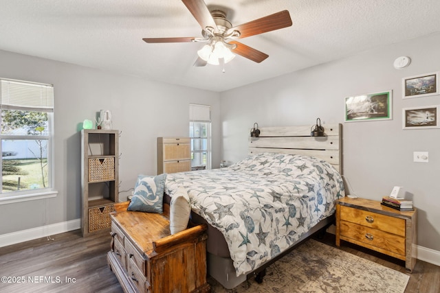 bedroom featuring ceiling fan, dark hardwood / wood-style floors, and a textured ceiling