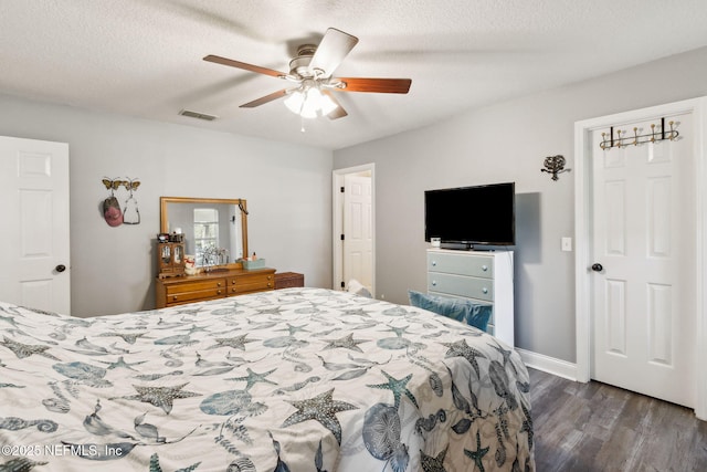 bedroom featuring ceiling fan, dark hardwood / wood-style flooring, and a textured ceiling