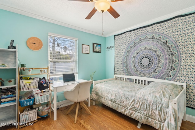 bedroom with hardwood / wood-style floors, ceiling fan, ornamental molding, and a textured ceiling