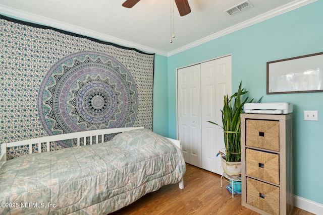 bedroom featuring ceiling fan, ornamental molding, a textured ceiling, wood-type flooring, and a closet