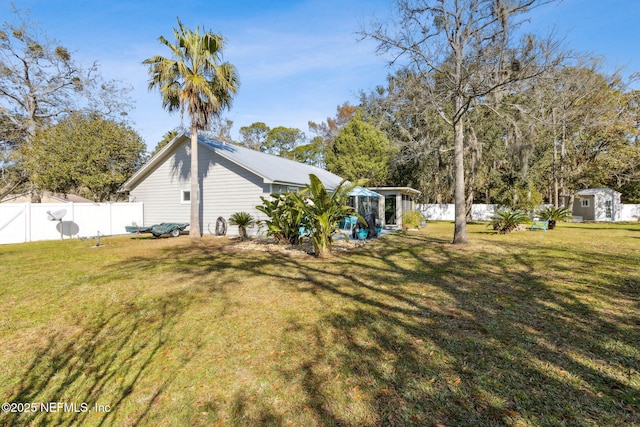 view of yard featuring a sunroom and a storage unit