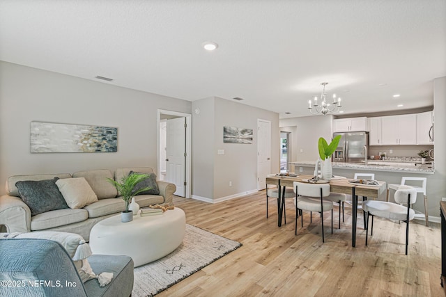 living room featuring light hardwood / wood-style flooring and a notable chandelier