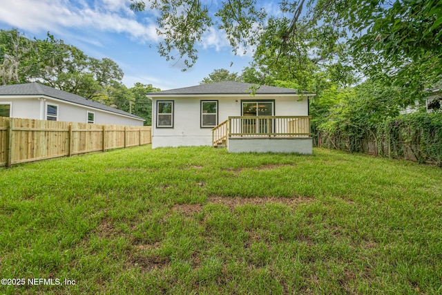 rear view of property featuring a wooden deck and a yard