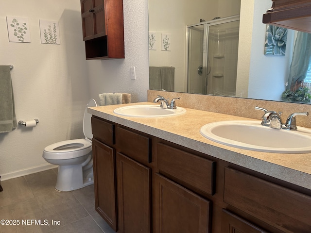 bathroom featuring toilet, vanity, tile patterned floors, and an enclosed shower