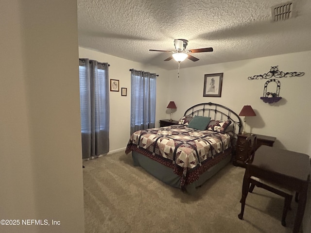 carpeted bedroom with ceiling fan and a textured ceiling