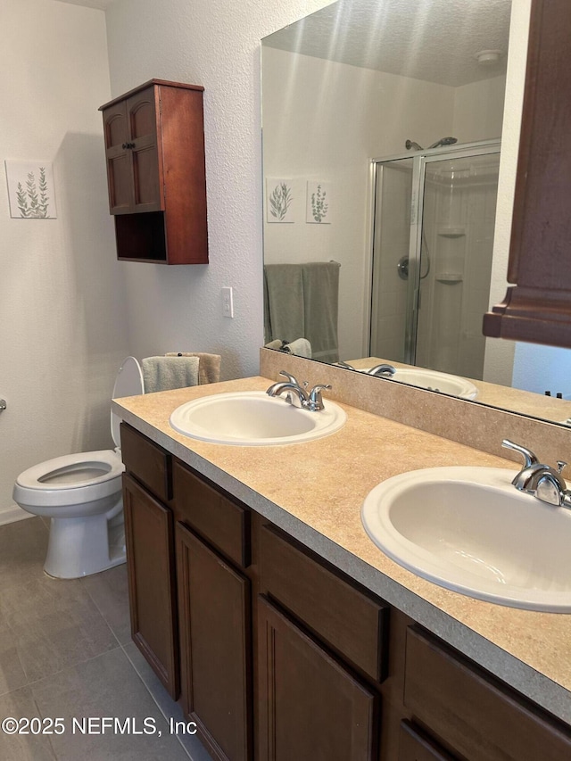 bathroom featuring tile patterned floors, vanity, toilet, and walk in shower