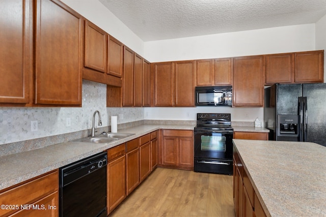 11786 Huckleberry Trl E, Macclenny, FL 32063 - kitchen featuring black appliances, a sink, light wood-type flooring, light countertops, and brown cabinets