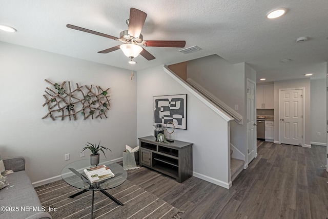 interior space featuring dark hardwood / wood-style floors, ceiling fan, and a textured ceiling