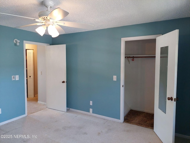 unfurnished bedroom with ceiling fan, a textured ceiling, light carpet, and a closet