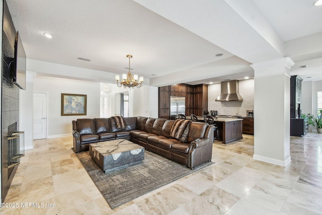 living room featuring a tile fireplace and an inviting chandelier