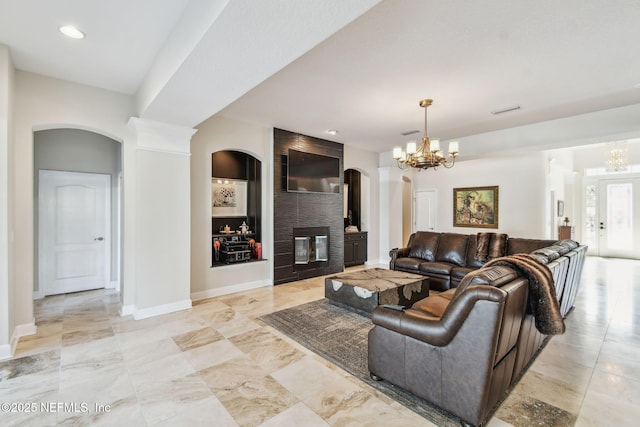 living room with built in shelves and an inviting chandelier