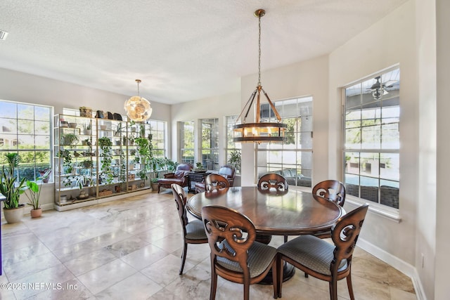 dining area with ceiling fan with notable chandelier and a textured ceiling