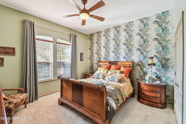 bedroom featuring light carpet, a textured ceiling, and ceiling fan