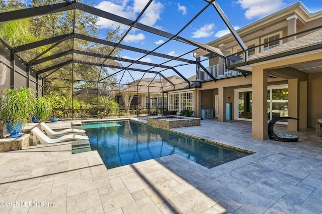 view of pool featuring glass enclosure, an in ground hot tub, and a patio area