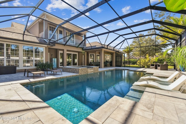 view of swimming pool with glass enclosure, an in ground hot tub, and a patio