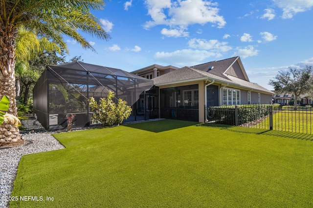 back of property featuring glass enclosure and a yard