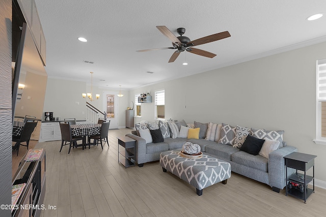 living room featuring crown molding, ceiling fan with notable chandelier, light hardwood / wood-style flooring, and a textured ceiling