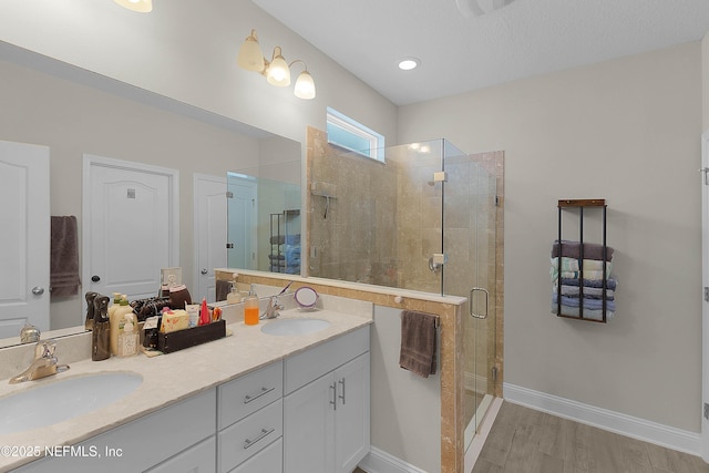 bathroom featuring hardwood / wood-style flooring, vanity, and walk in shower