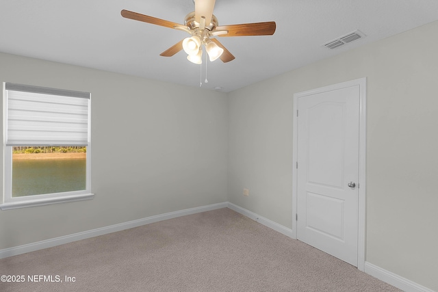 carpeted spare room featuring ceiling fan