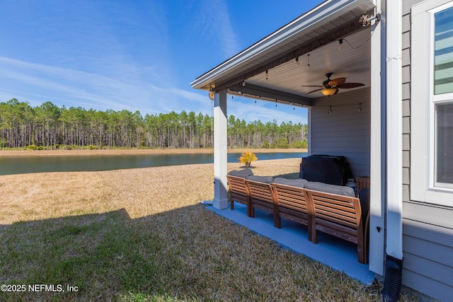 view of yard featuring a water view and ceiling fan