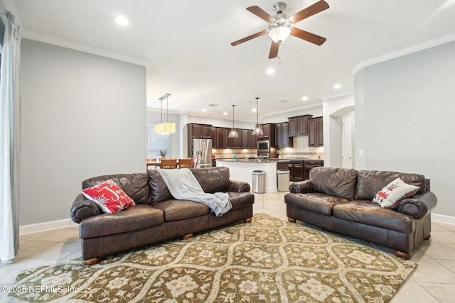 living room featuring ceiling fan, light tile patterned floors, and crown molding