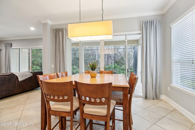 dining room featuring light tile patterned floors, crown molding, and a healthy amount of sunlight