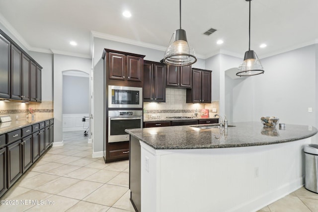 kitchen featuring stainless steel appliances, sink, hanging light fixtures, light tile patterned flooring, and dark brown cabinets