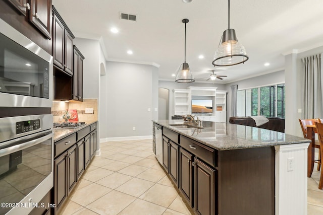 kitchen featuring decorative light fixtures, ceiling fan, sink, stainless steel appliances, and dark brown cabinets