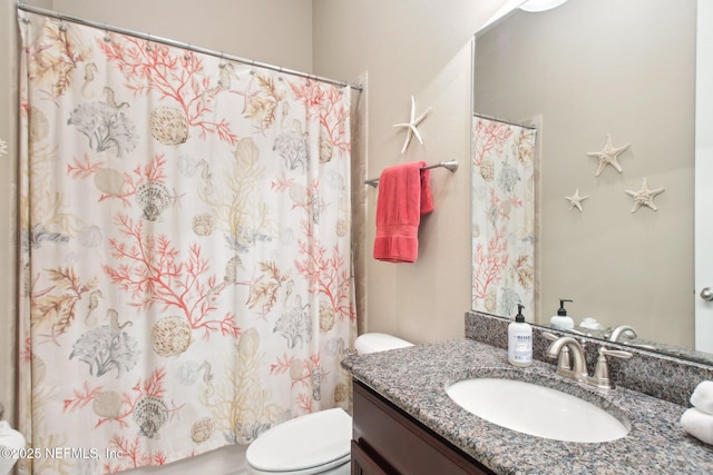 bathroom featuring toilet, vanity, and walk in shower