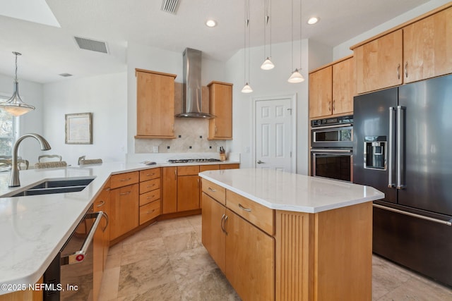 kitchen with a center island, wall chimney exhaust hood, stainless steel appliances, sink, and hanging light fixtures