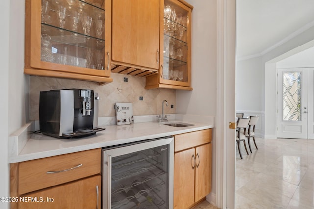 kitchen featuring sink, ornamental molding, wine cooler, and decorative backsplash