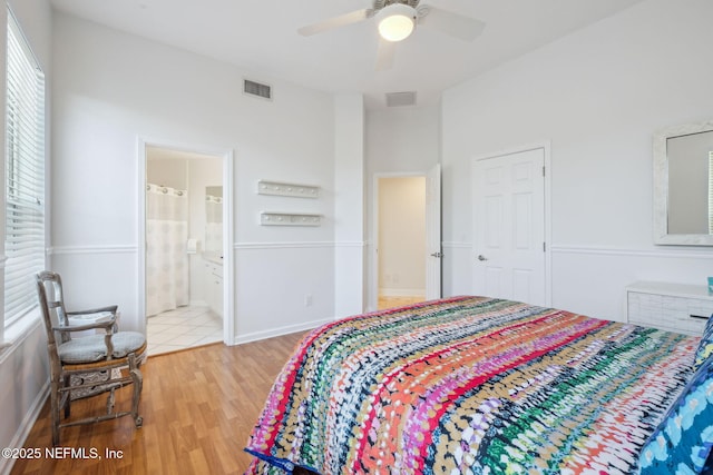 bedroom with ceiling fan, wood-type flooring, and ensuite bath