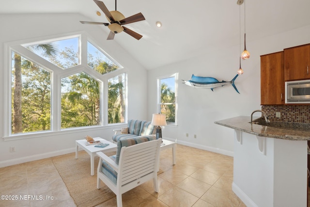 sunroom with sink, vaulted ceiling, ceiling fan, and plenty of natural light