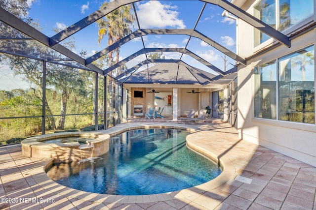 view of swimming pool with an in ground hot tub, a lanai, a patio area, and ceiling fan