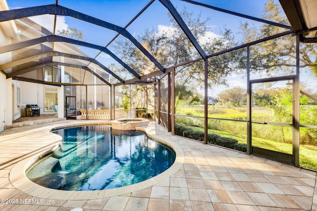 view of pool with a patio, an in ground hot tub, glass enclosure, and a grill