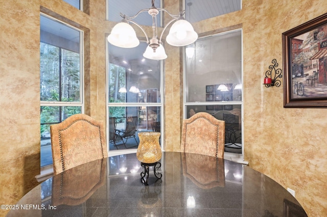 dining room with an inviting chandelier and a high ceiling