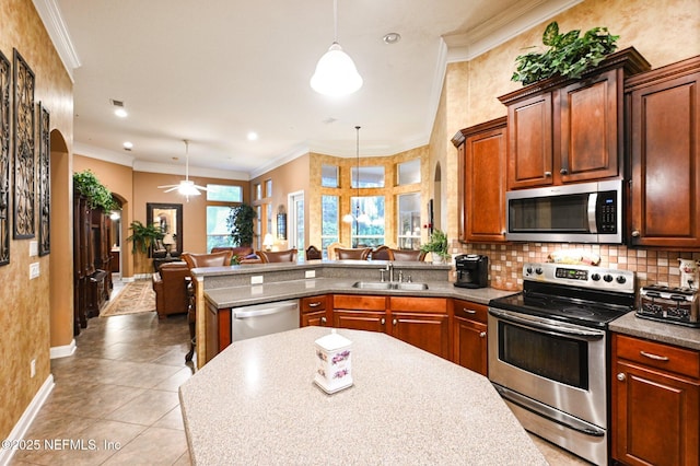 kitchen with stainless steel appliances, ornamental molding, light tile patterned flooring, decorative light fixtures, and kitchen peninsula