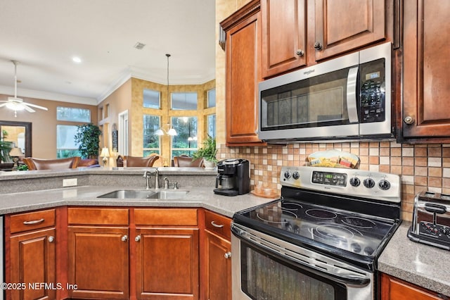 kitchen with appliances with stainless steel finishes, sink, a wealth of natural light, and backsplash