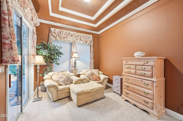 living area with a raised ceiling, crown molding, and carpet flooring