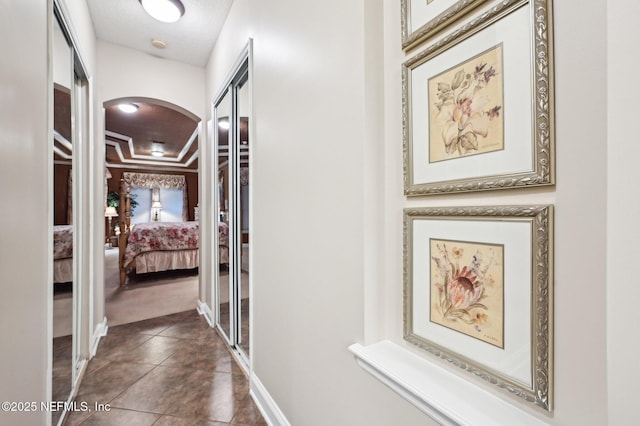 hallway featuring dark tile patterned flooring