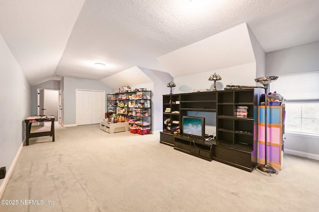 interior space featuring vaulted ceiling, a textured ceiling, and carpet flooring