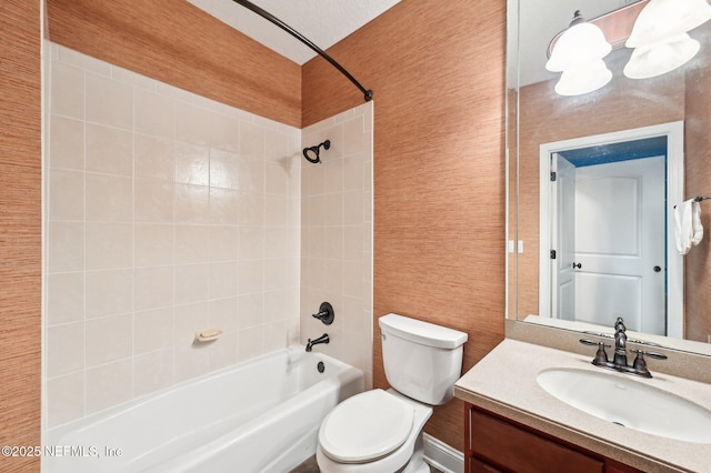 full bathroom featuring tiled shower / bath, vanity, and toilet